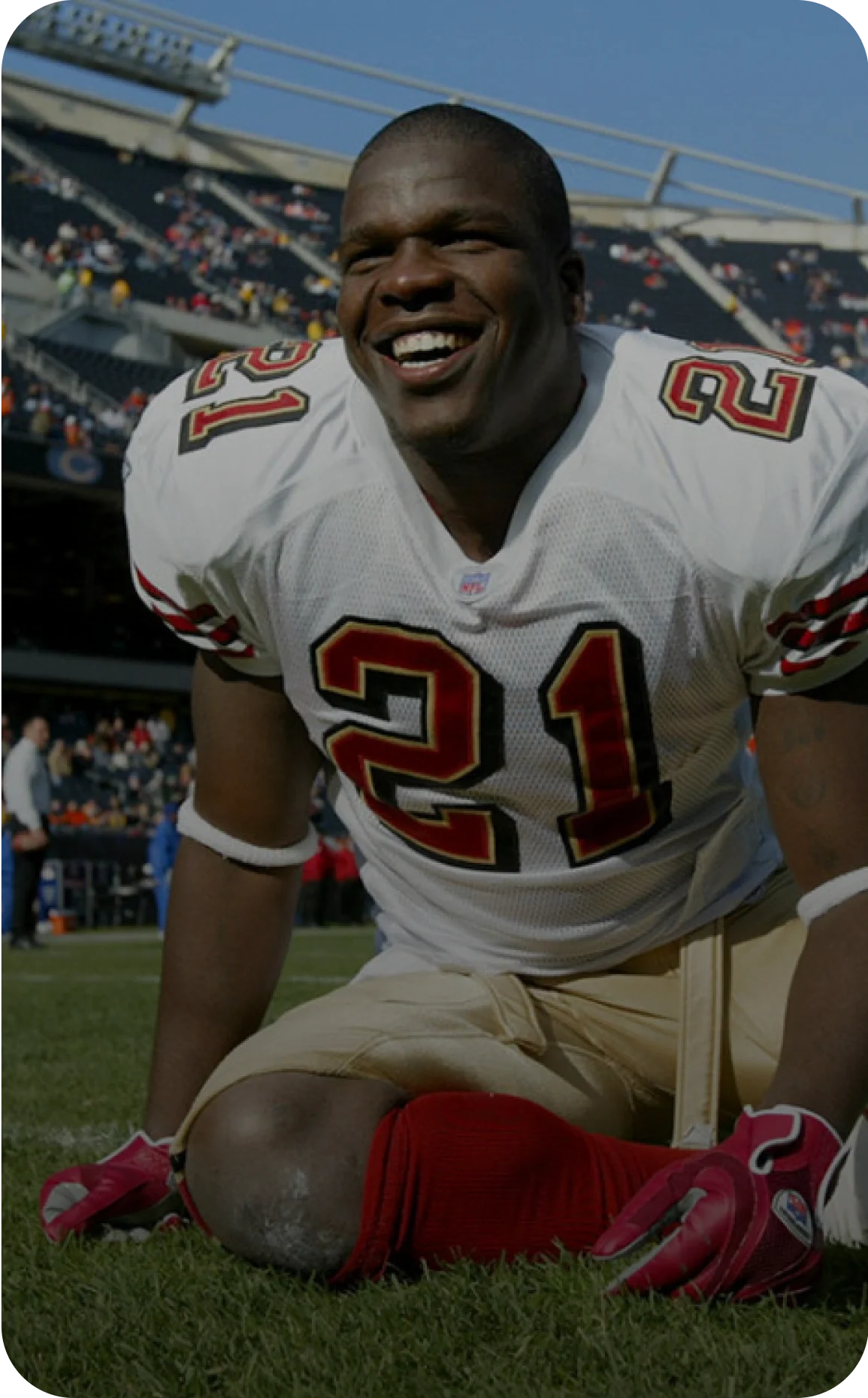 Photo of a man wearing a football jersey with the number 21, smiling while seated on the field in a stadium, labeled as Frank Gore, 5x Pro Bowl NFL Legend.