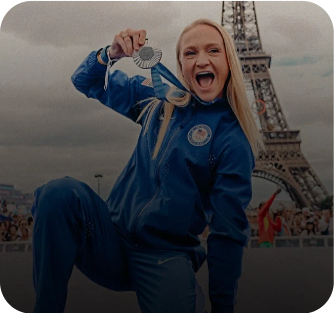 Photo of a woman celebrating with a medal in front of the Eiffel Tower, labeled as Sarah Bacon, Olympian, Silver Medalist, 3x World Silver Medalist, 5x NCAA Champion.