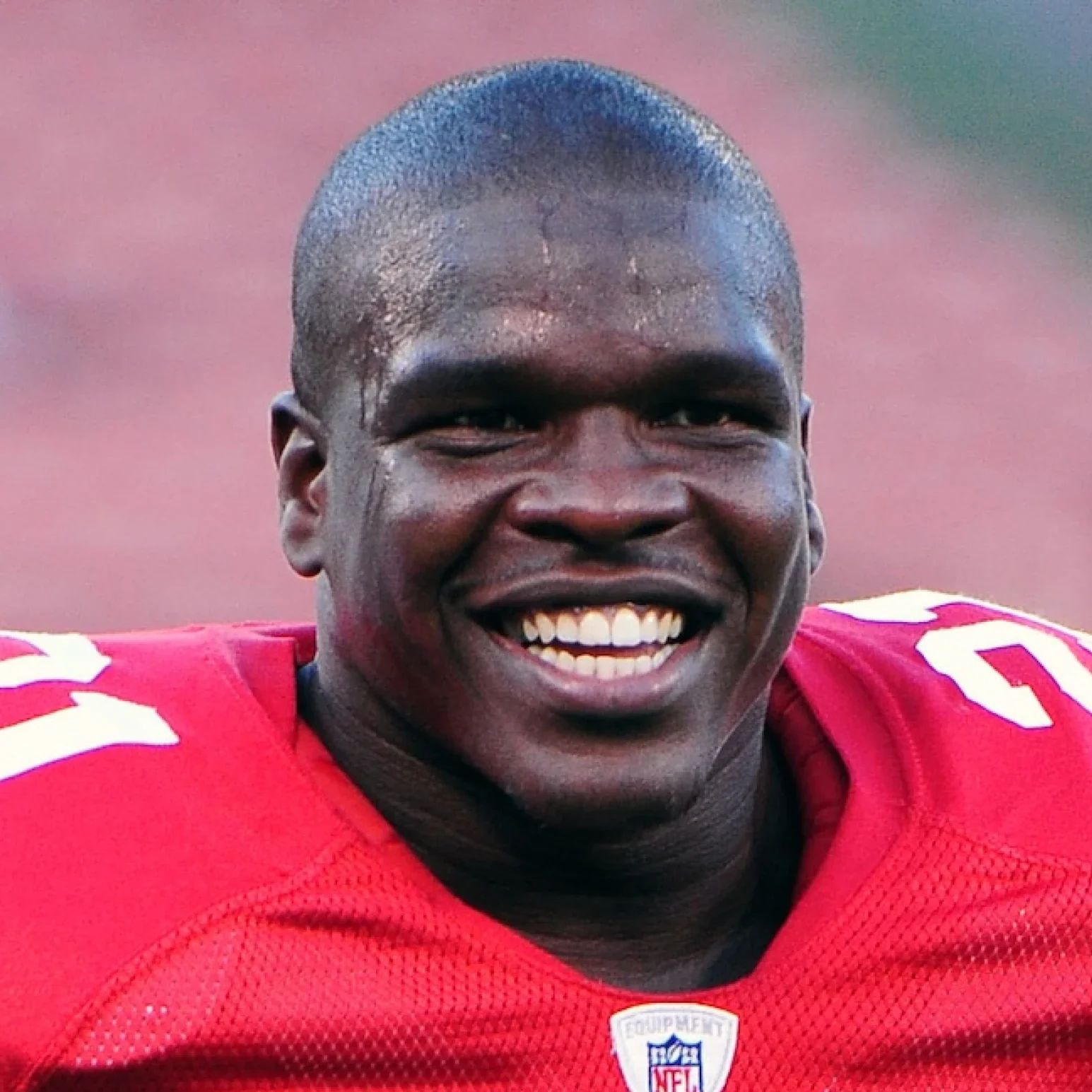Person wearing a red sports jersey with number 21 on a field